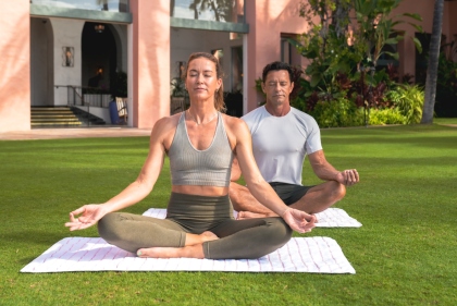 朝の光に包まれた芝生で、ゲストが静かに呼吸を整えるヨガのひととき。