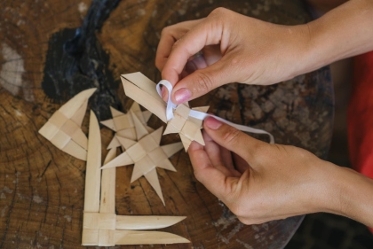 ハワイの伝統工芸「ラウハラ編み」を体験する様子。葉を丁寧に編み込み、美しい形をつくり上げていく。