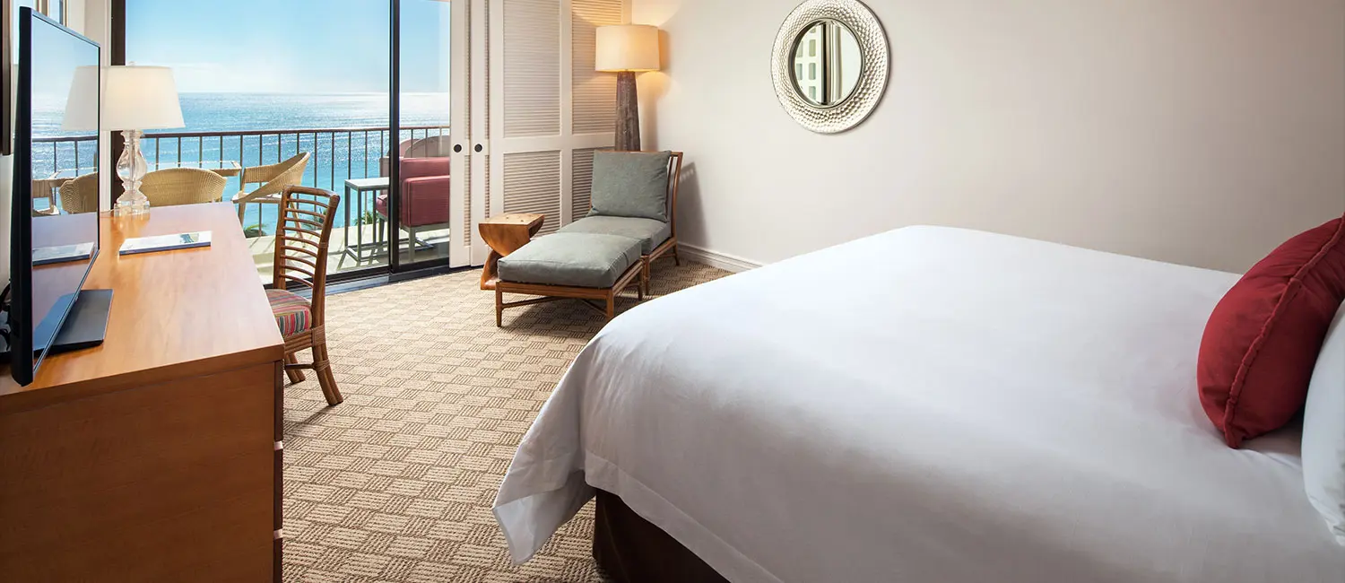 オーシャンビューのツインルーム。モダンな木製家具とアートが調和する室内