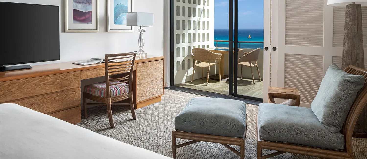 バルコニー付きの客室。デスクとチェアから海を眺めるくつろぎの時間