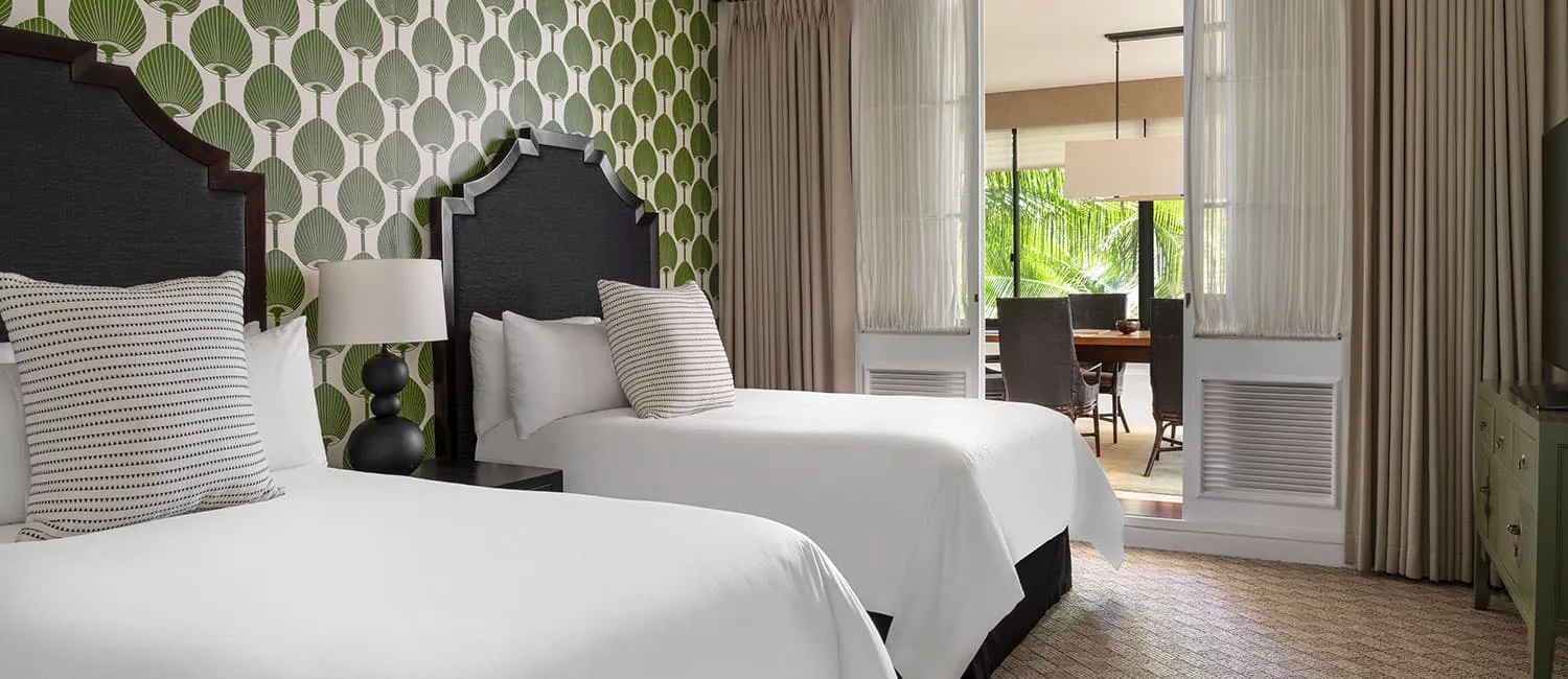 グリーンの壁紙とツインベッドを備えたベッドルーム