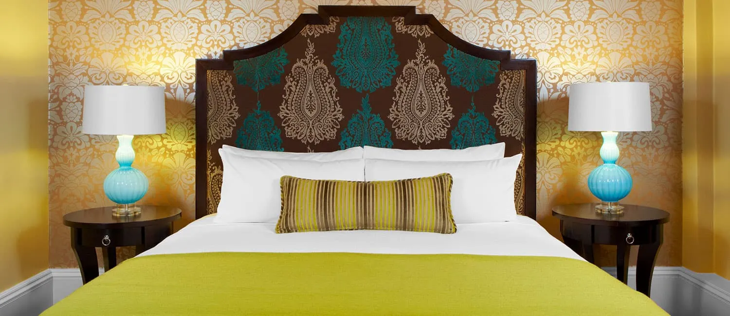 イエローとゴールドの色調でまとめられた明るいベッドルーム