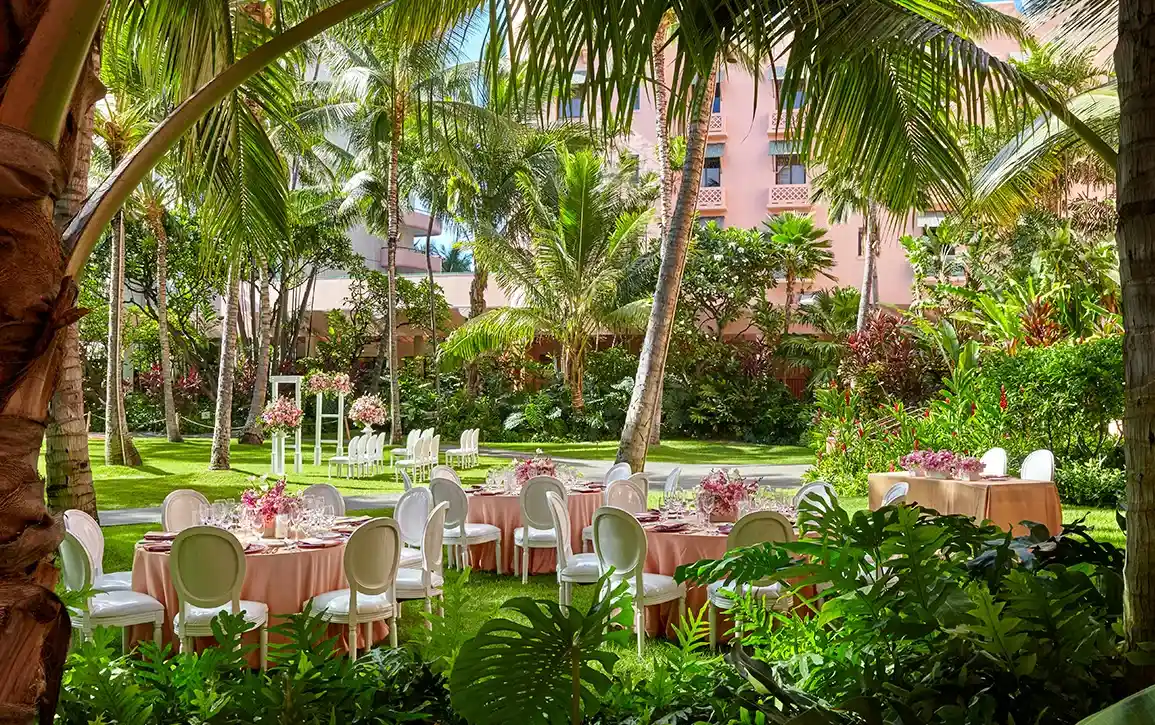 ダイヤモンドヘッドとワイキキビーチを望む芝生に、白い円卓を配した屋外ウェディングレセプション会場